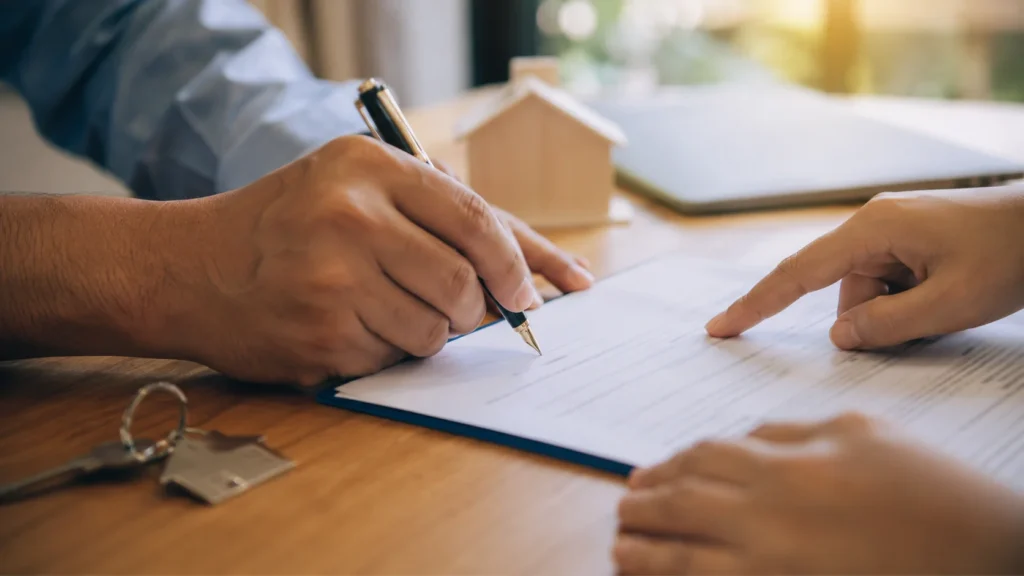 Hands signing a deed to fund trust